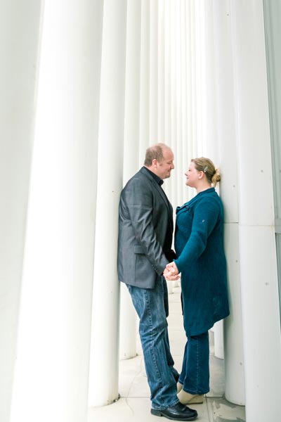 couple holding hands between columns