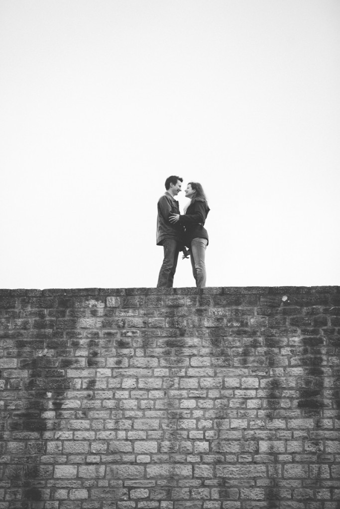 le couple se tient les mains debout sur un mur