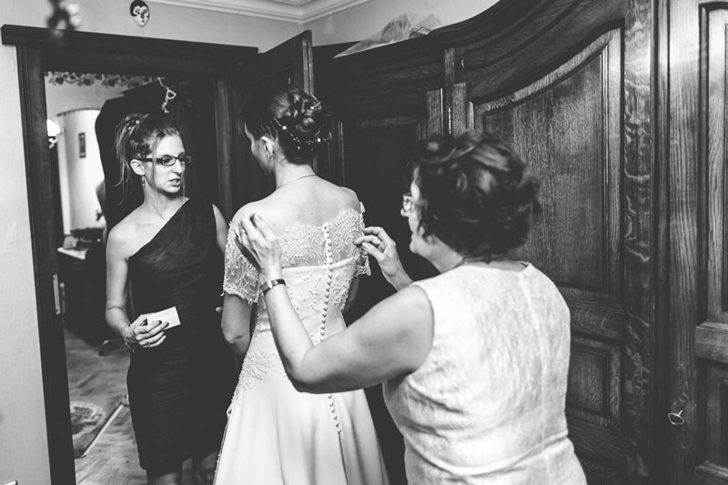 family members adjusting the wedding dress of the bride