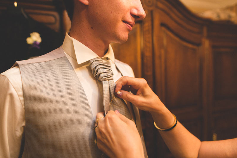 adjusting the groom's tie