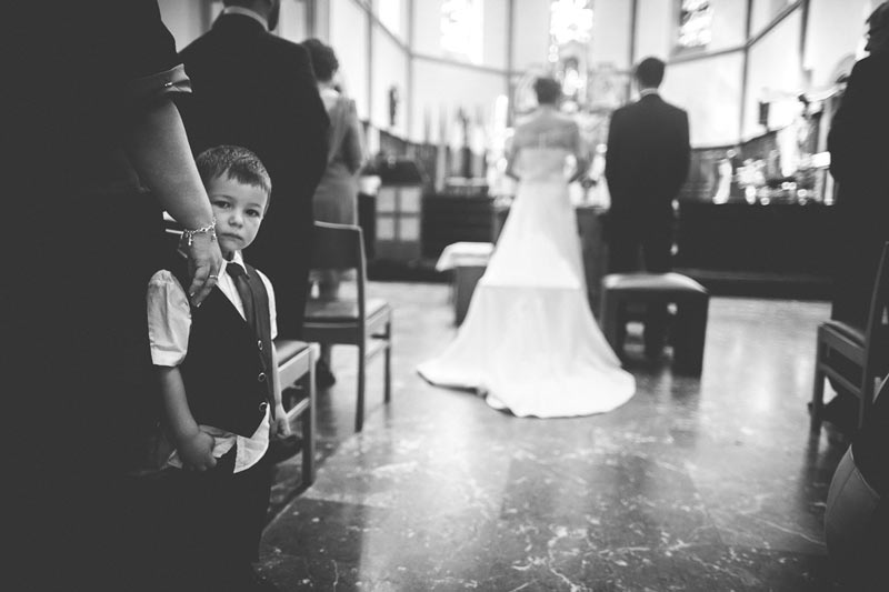 kid staring at the photographer during wedding ceremony