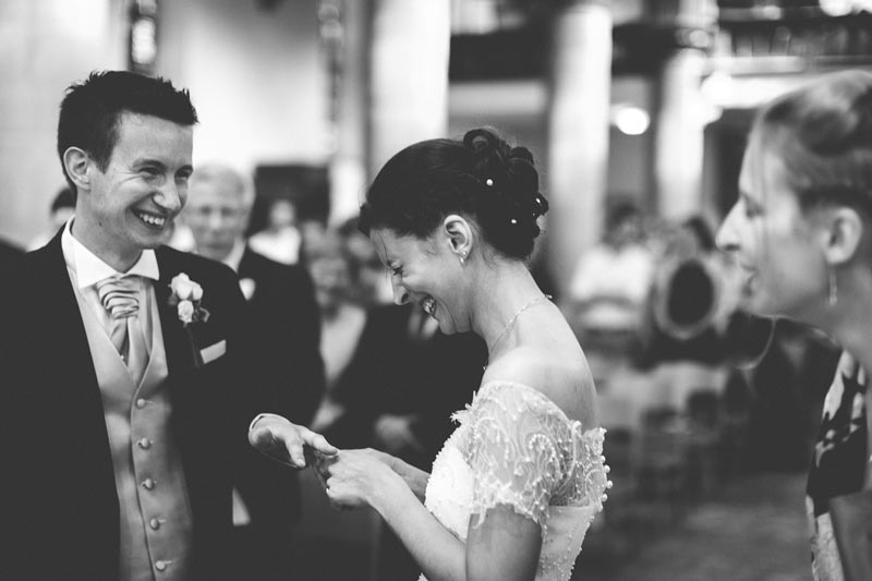 bride and groom laughing when wedding ring is too small to fit finger