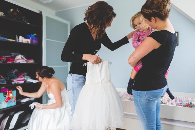 the bride looks for clothes while her daugther gets ready for wedding