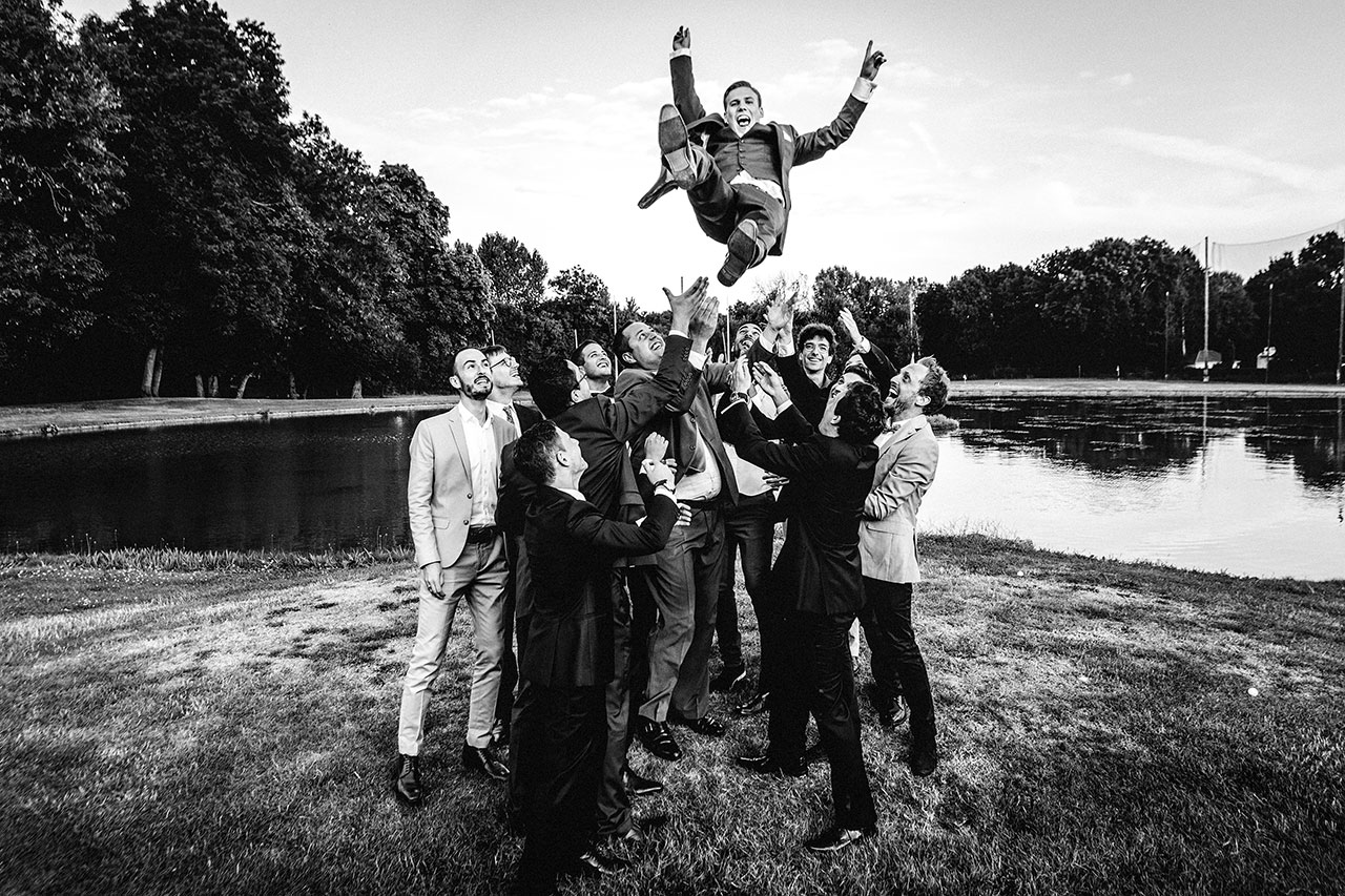 the groom is thrown in the air at wedding reception