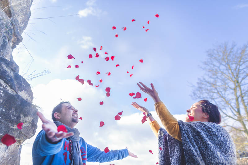 throwing flowers in the air for a great engagement photo