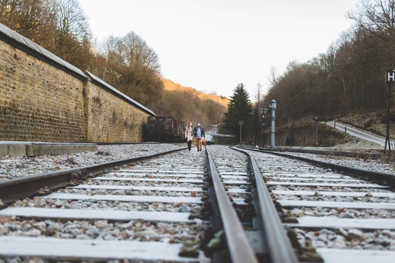 un couple marche sur les rails d'une voie ferrée