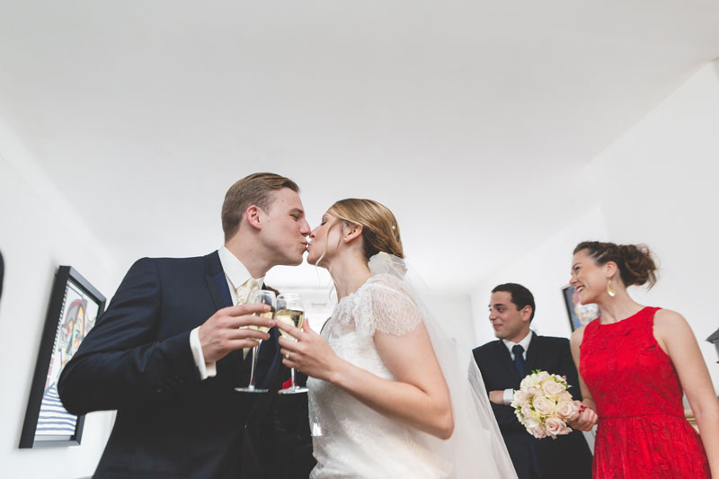 bride and groom kissing and drinking champagne
