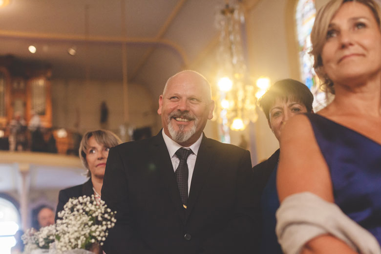 father smiles while his daughter is getting married