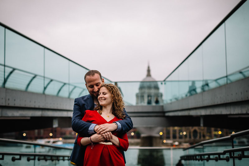 couple posing under the Millenium bridge London