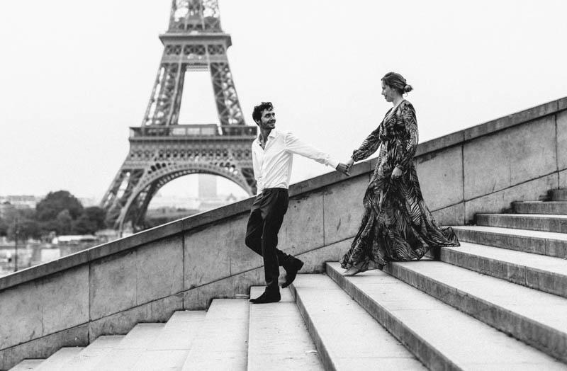 couple walking down stairs in front of eiffel tower