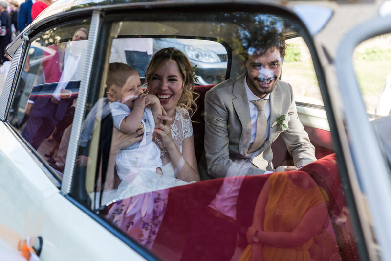 les mariés et leur bébé dans la voiture